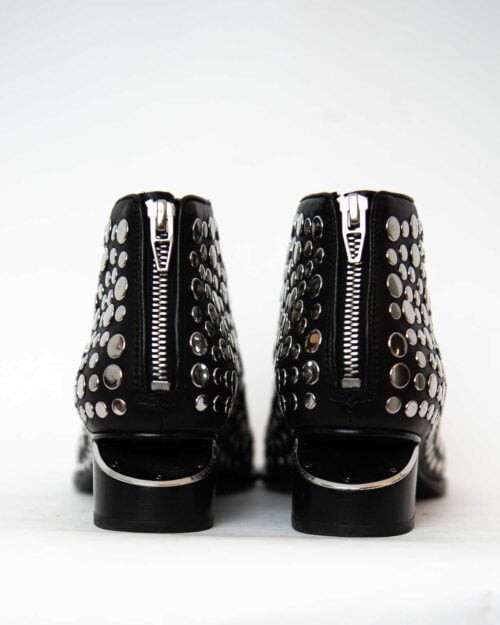 Alexander Wang Kori Studded Boots in Schwarz mit silbernen Nieten und charakteristischem Cut-Out-Absatz. Edgy, urban und luxuriös – ein Statement-Piece für jeden Look.