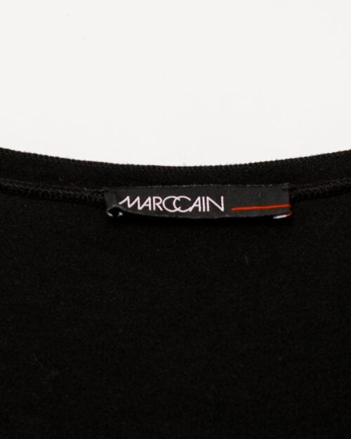 Schwarzes Marc Cain Kleid aus Modal und Seide mit Raffung im Brustbereich, langärmelig, figurbetont geschnitten, auf weißem Hintergrund hängend.