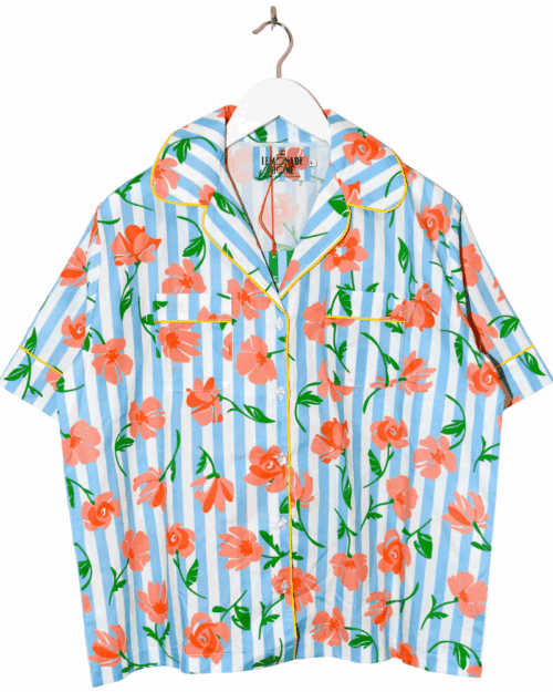 LEMONADE HOME SECONDHAND BLOUSE-9-Photoroom_11zon Kurzärmlige Bluse mit blau-weißen vertikalen Streifen und orangefarbenem Blumenmuster. Die Bluse hat gelbe Paspeln an Kragen und Knopfleiste, sowie zwei Brusttaschen. Sie hängt auf einem weißen Kleiderbügel.