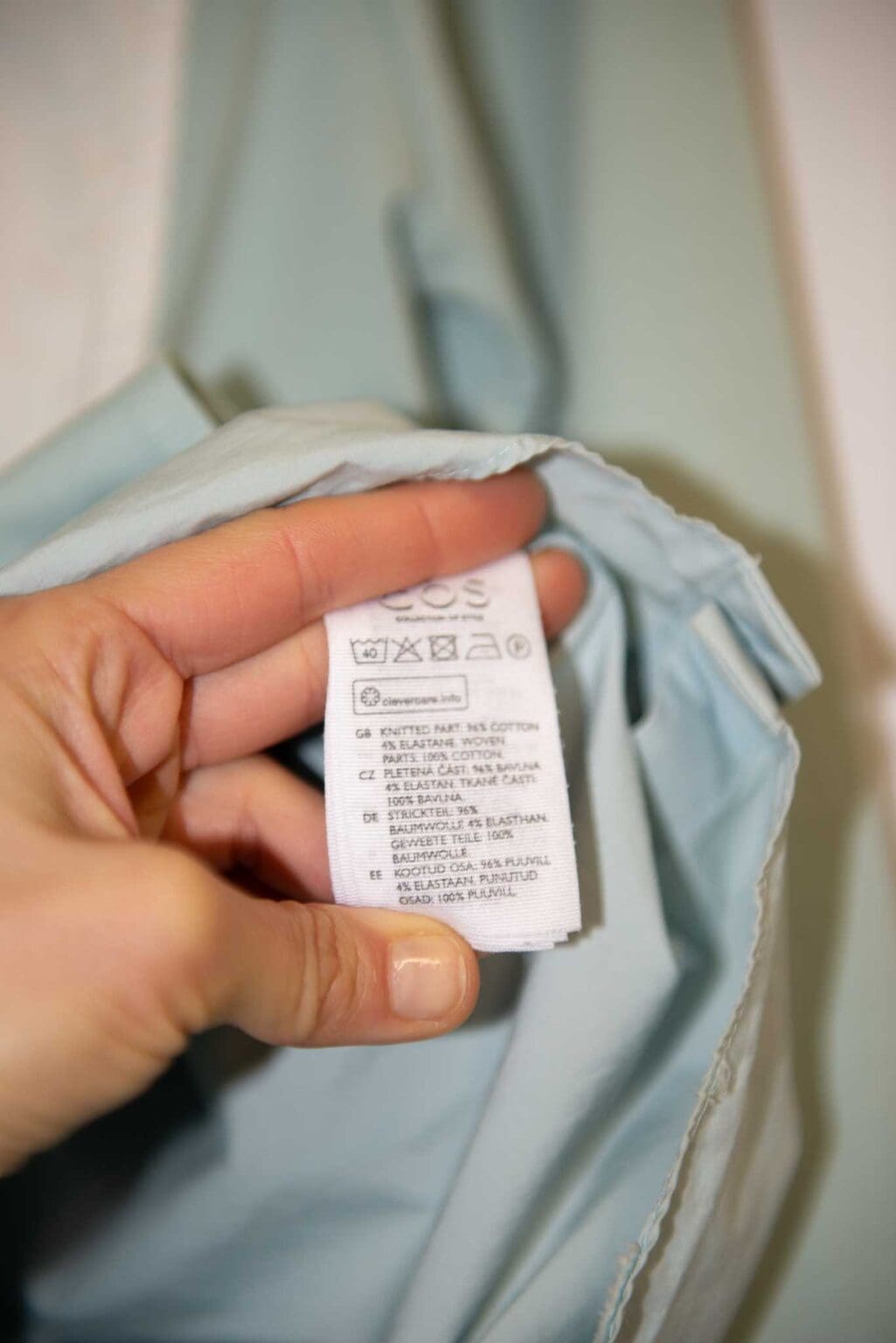 Hellblaues COS Damen-Top mit 3/4-&Auml;rmeln, asymmetrischem Lagen-Look und einer wei&szlig;en aufgesetzten Brusttasche. Hochwertiges Secondhand-Designer-Teil, verf&uuml;gbar auf Monkky.ch.