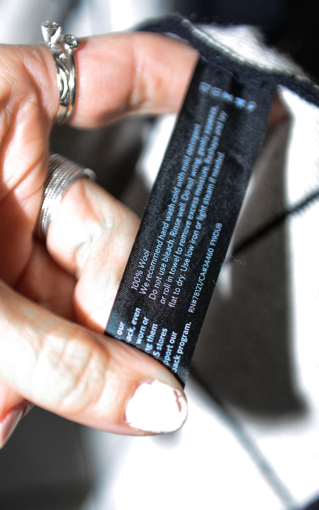 Schwarzer Eileen Fisher Cardigan mit wei&szlig;em Karomuster, offenes Design, zeitlose Secondhand-Mode.