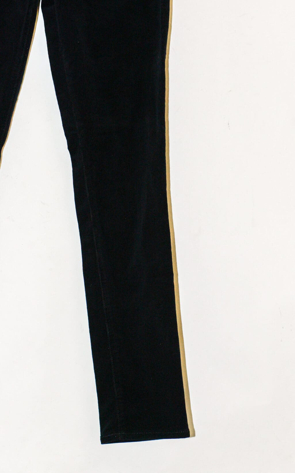 Eine Nahaufnahme des Adriano Goldschmied Cigarette Leg &ndash; W27 zeigt ein schwarzes Hosenbein mit einem beigen Streifen an der Au&szlig;enseite vor einem wei&szlig;en Hintergrund.