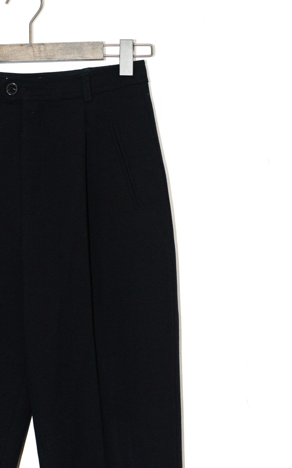 Die Closed Arlo Hose &ndash; W26, eine schwarze Anzughose, wird auf einem h&ouml;lzernen Kleiderb&uuml;gel vor einem wei&szlig;en Hintergrund pr&auml;sentiert, wobei nur der obere Teil sichtbar ist.