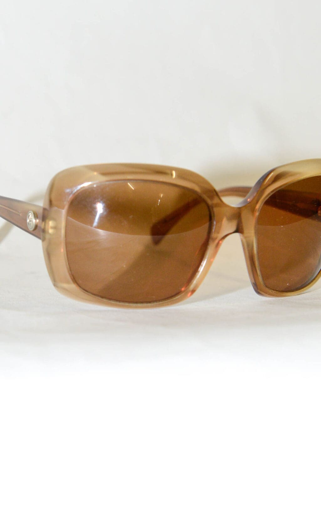 Die Sonnenbrille von Giorgio Armani zeichnet sich durch &uuml;bergro&szlig;e, braun get&ouml;nte Gl&auml;ser und dicke, durchscheinende Rahmen aus, die vor einem schlichten wei&szlig;en Hintergrund zu sehen sind.