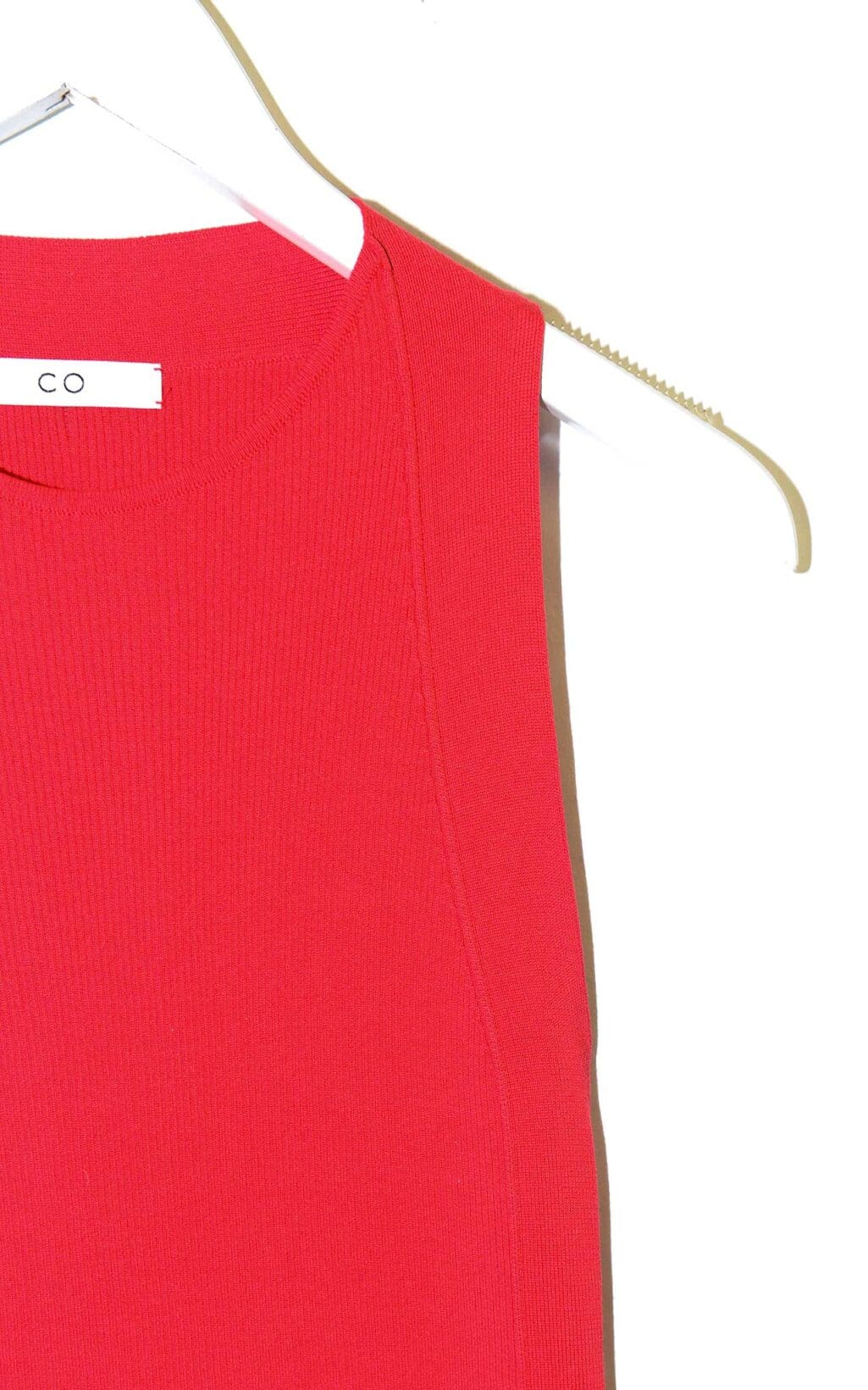 &Auml;rmelloses rotes Top von CO aus feinem Seidenstrick, schlicht geschnitten, auf einem wei&szlig;en Kleiderb&uuml;gel vor hellem Hintergrund pr&auml;sentiert.
