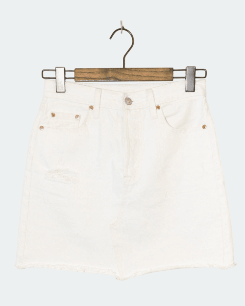 Der Levi’s Jeansrock – W26 ist ein weißer Jeansrock mit ausgefranstem Saum, Kupferknöpfen und Taschen vorne und hinten, der auf einem hölzernen Kleiderbügel vor einem hellen Hintergrund präsentiert wird. Der Levi’s Jeansrock – W26 ist ein weißer Jeansrock mit ausgefranstem Saum, Kupferknöpfen und Taschen vorne und hinten, der auf einem hölzernen Kleiderbügel vor einem hellen Hintergrund präsentiert wird.