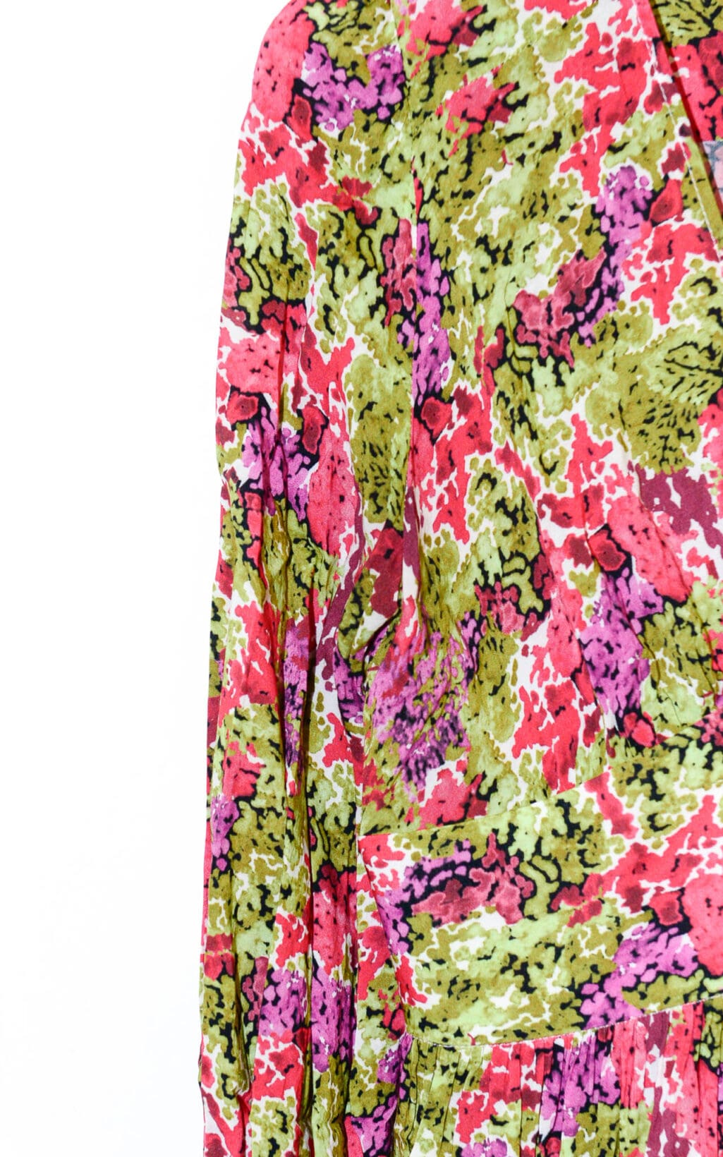 Eine Nahaufnahme des Lemonade Fleurie Kleids &ndash; Gr. 40, mit einem lebendigen abstrakten Muster in Gr&uuml;n, Rosa, Rot und Schwarz auf dem Stoff, das &Auml;rmel und Oberteil vor einem wei&szlig;en Hintergrund hervorhebt.