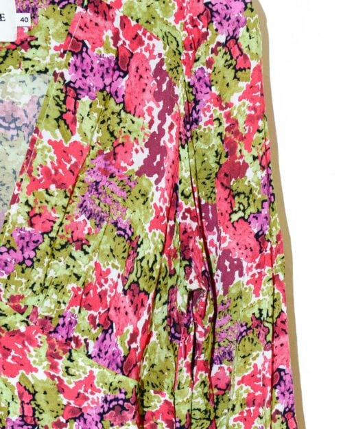 Eine Nahaufnahme des Lemonade Fleurie Kleides (Gr. 40) zeigt einen farbenfrohen abstrakten Camouflage-Stoff in Rosa-, Grün-, Rot- und Weißtönen mit Falten und einem sichtbaren Größenetikett mit der Aufschrift „40“.