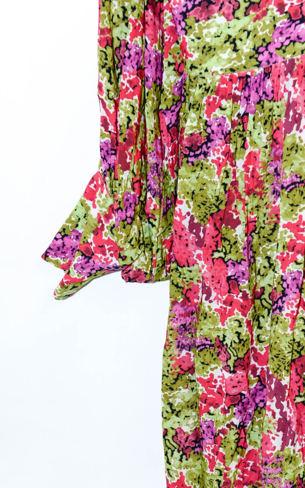 Eine Nahaufnahme des Lemonade Fleurie Kleids &ndash; Gr. 40, ein farbenfrohes Langarmkleid mit einem lebendigen abstrakten Blumenmuster in Pink, Rot, Gr&uuml;n und Schwarz und Faltendetails an den &Auml;rmeln und der Taille.