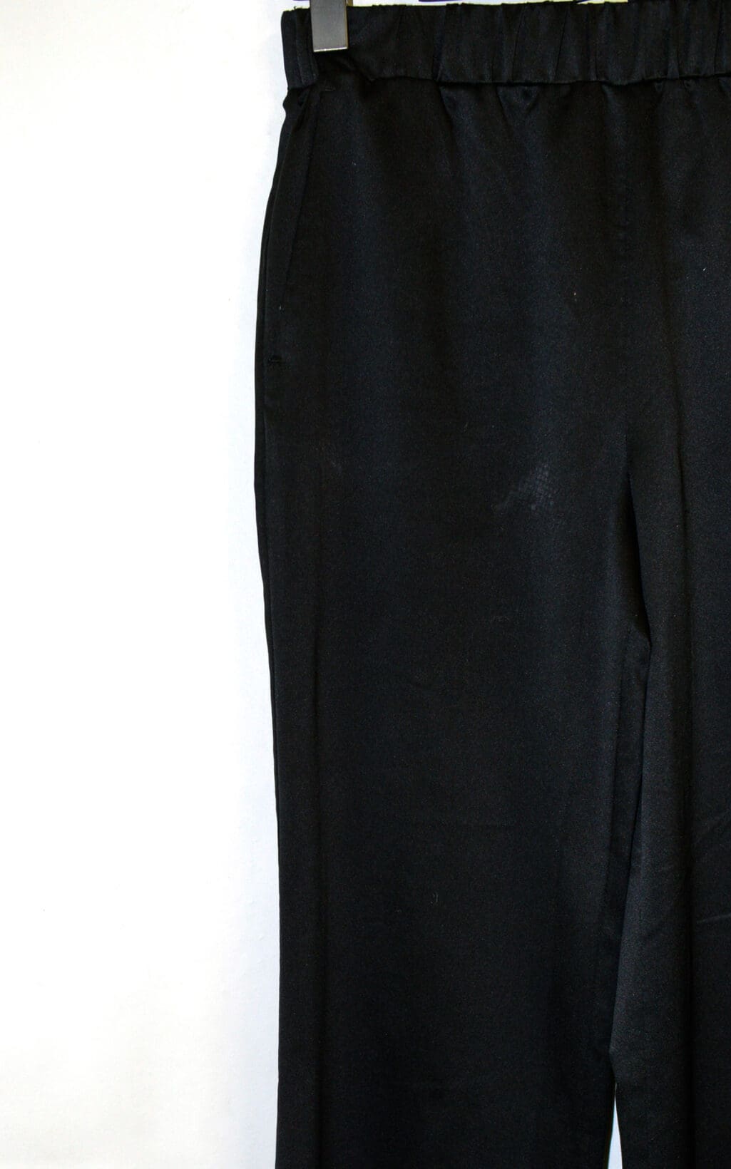 Maxmara Leisure Hose in Gr&ouml;&szlig;e S, schwarze High-Waist-Hose mit elastischem Bund, h&auml;ngt an einem Clip-B&uuml;gel vor wei&szlig;em Hintergrund. Nur das obere Hosenst&uuml;ck ist zu sehen.