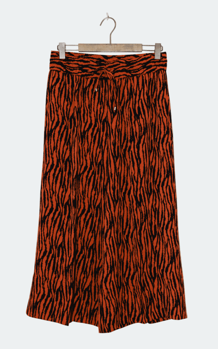 Die InWear Quiana Culotte-Hose in Größe 40 verfügt über ein orange-schwarzes Tigerstreifenmuster, einen Bund zum Binden und wird auf einem Holzbügel vor einem schlichten Hintergrund präsentiert.
