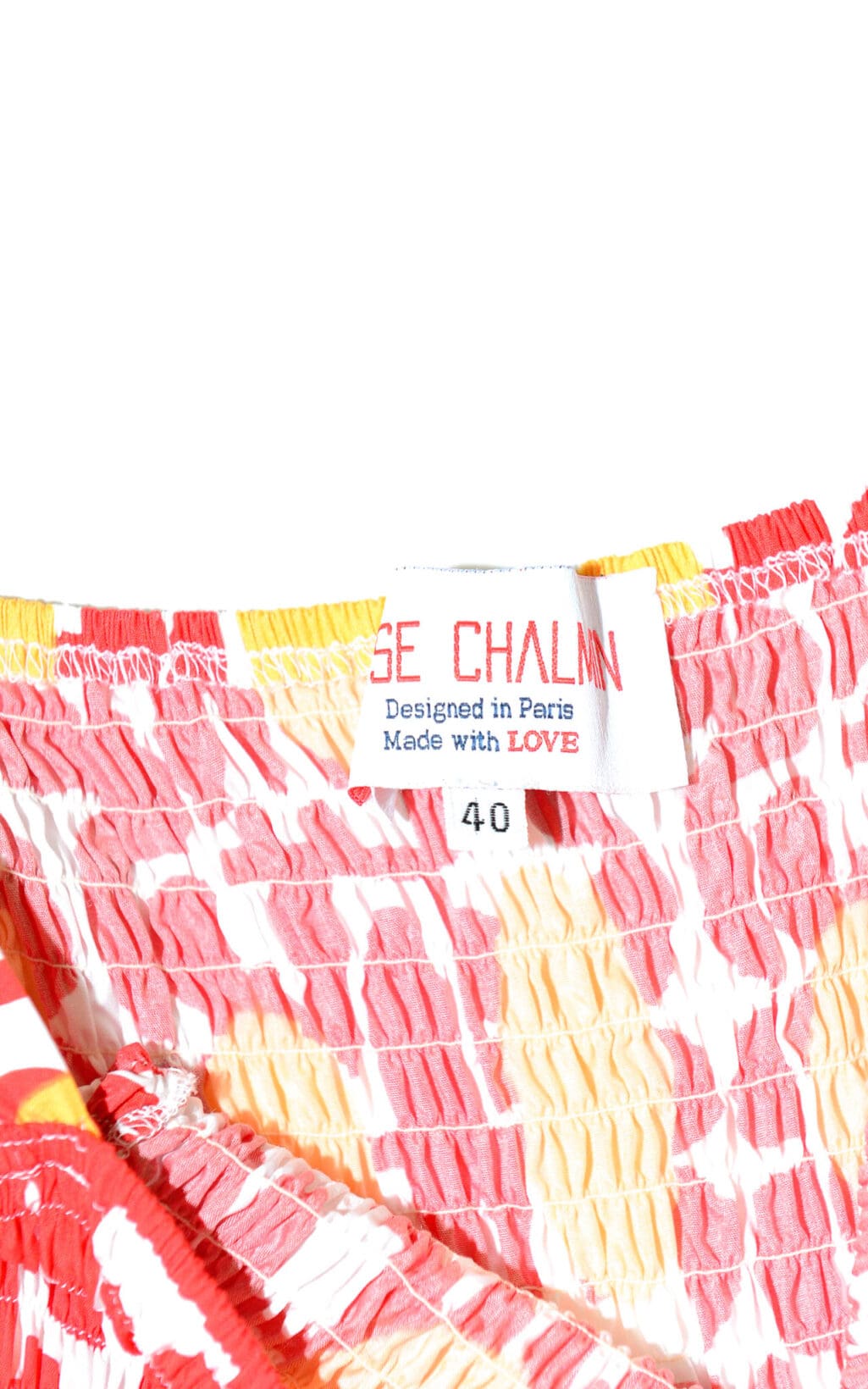 Eine Nahaufnahme des Maxikleid-Etiketts von Elise Chalmin Paris auf rot-gelb-wei&szlig;em Strukturstoff zeigt &bdquo;Designed in Paris, Made with LOVE&ldquo; und Gr&ouml;&szlig;e 40.