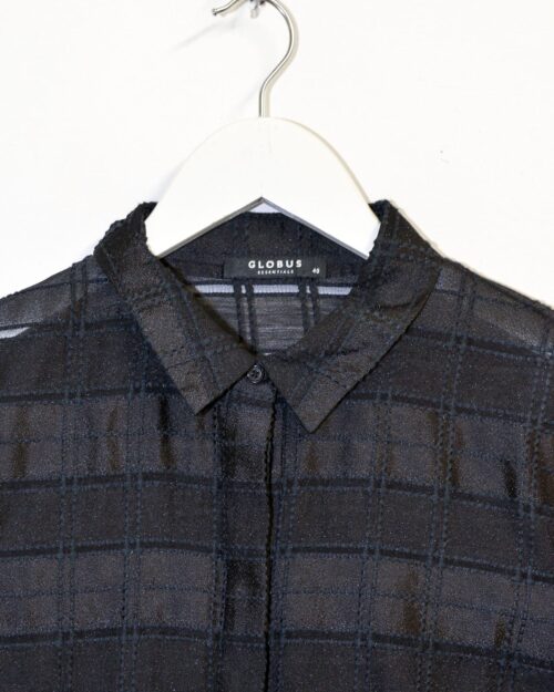 Die Globus Bluse &bdquo;Doha&ldquo; in Gr&ouml;&szlig;e 40 aus schwarzem, transparentem Stoff mit dezentem Karomuster und langen &Auml;rmeln wird auf einem wei&szlig;en Kleiderb&uuml;gel vor wei&szlig;em Hintergrund pr&auml;sentiert.