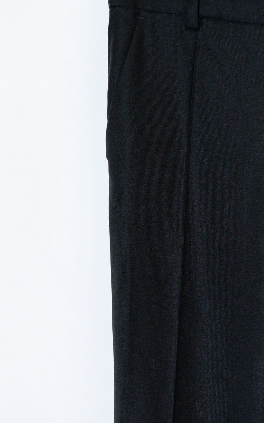 Nahaufnahme der rechten Seite der JOSEPH 100 % Wolle Chino Hose in Gr&ouml;&szlig;e 38, schwarz, vor einem schlichten wei&szlig;en Hintergrund, wobei Bund, Tasche und ein Teil des Beins hervorgehoben werden.