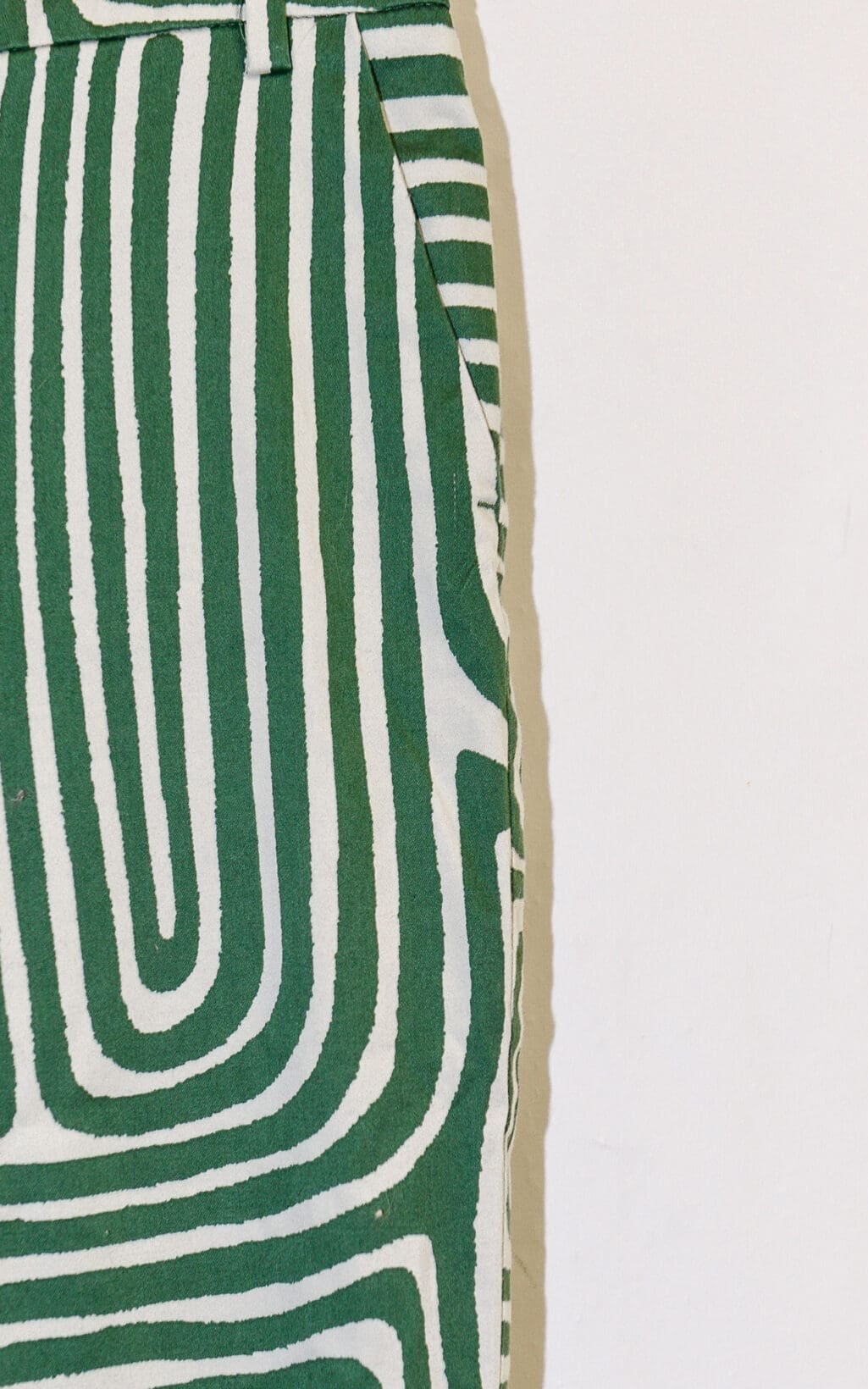 Nahaufnahme der EMME Marella Hose (Gr. 40) mit gr&uuml;n-wei&szlig;em wellenf&ouml;rmigem, labyrinthartigem Muster und sichtbarer Taschennaht auf wei&szlig;em Hintergrund.