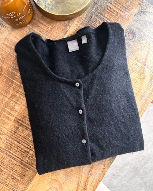 Schwarzer Cardigan mit Knopfleiste, vermutlich aus weichem, flauschigem Material.