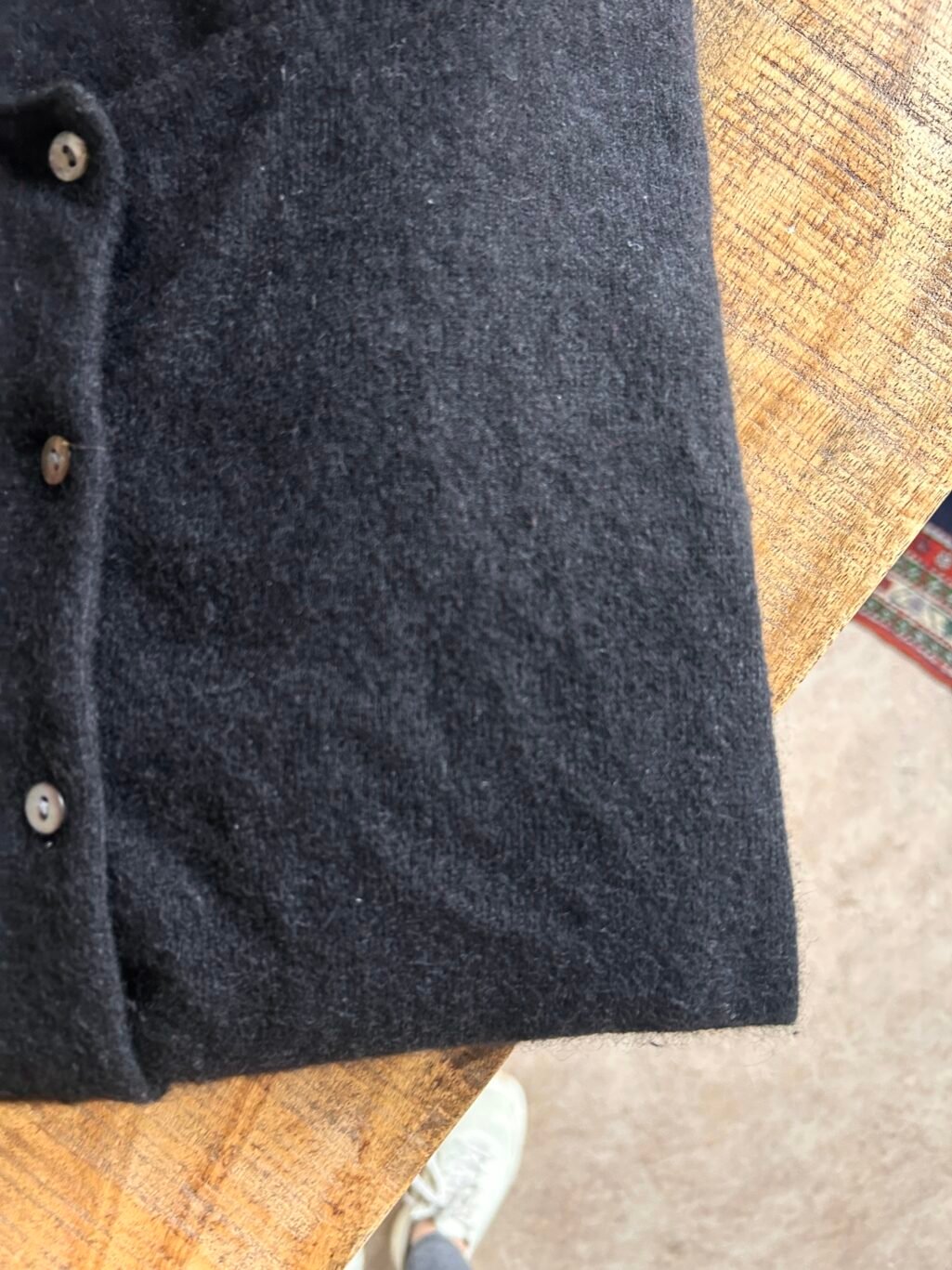 Schwarzer Cardigan mit Knopfleiste, vermutlich aus weichem, flauschigem Material.