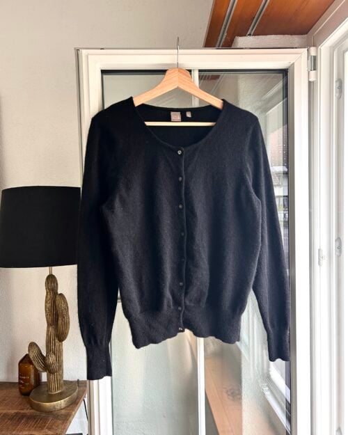 Schwarzer Cardigan mit Knopfleiste, vermutlich aus weichem, flauschigem Material.