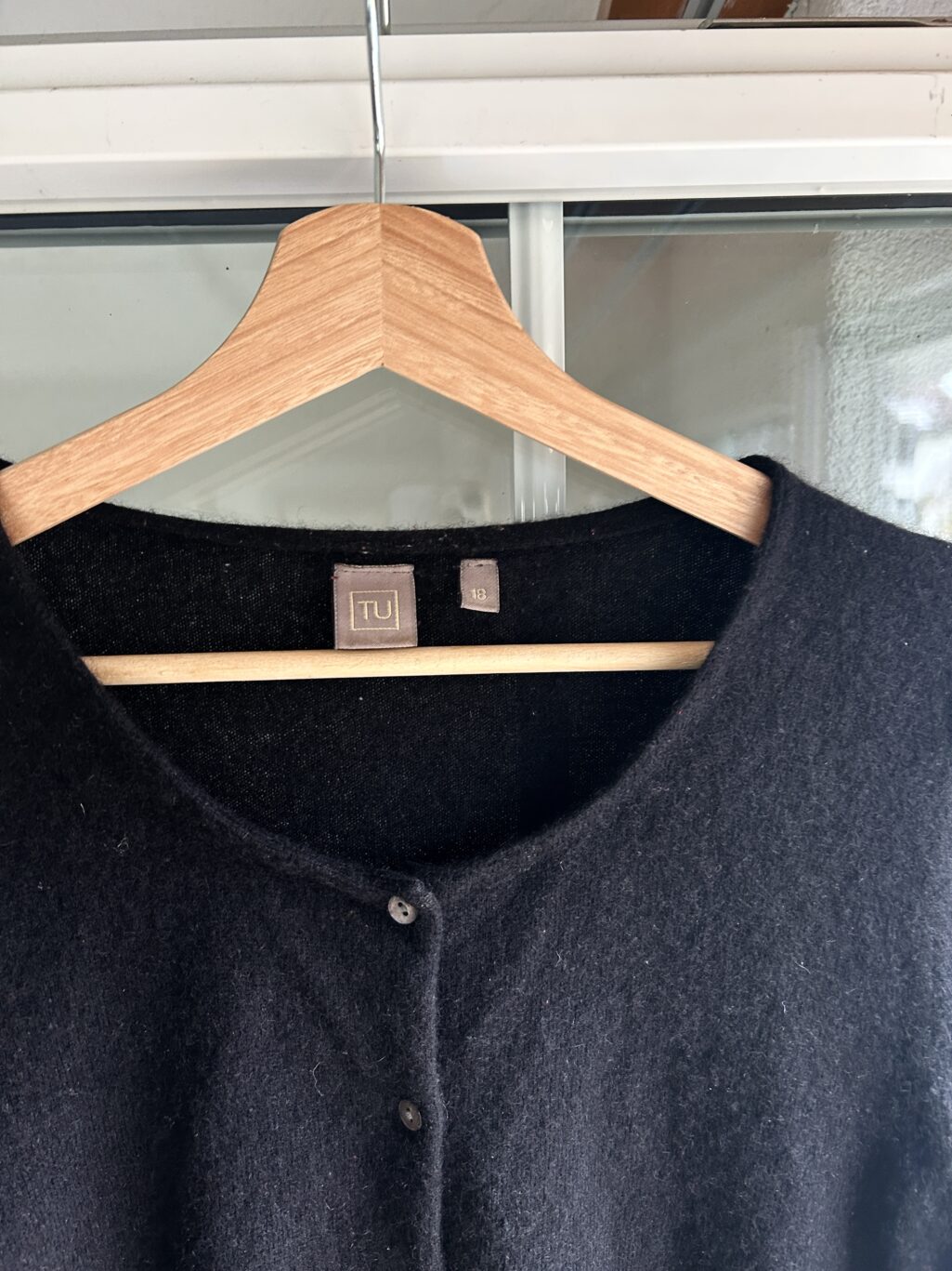 Schwarzer Cardigan mit Knopfleiste, vermutlich aus weichem, flauschigem Material.