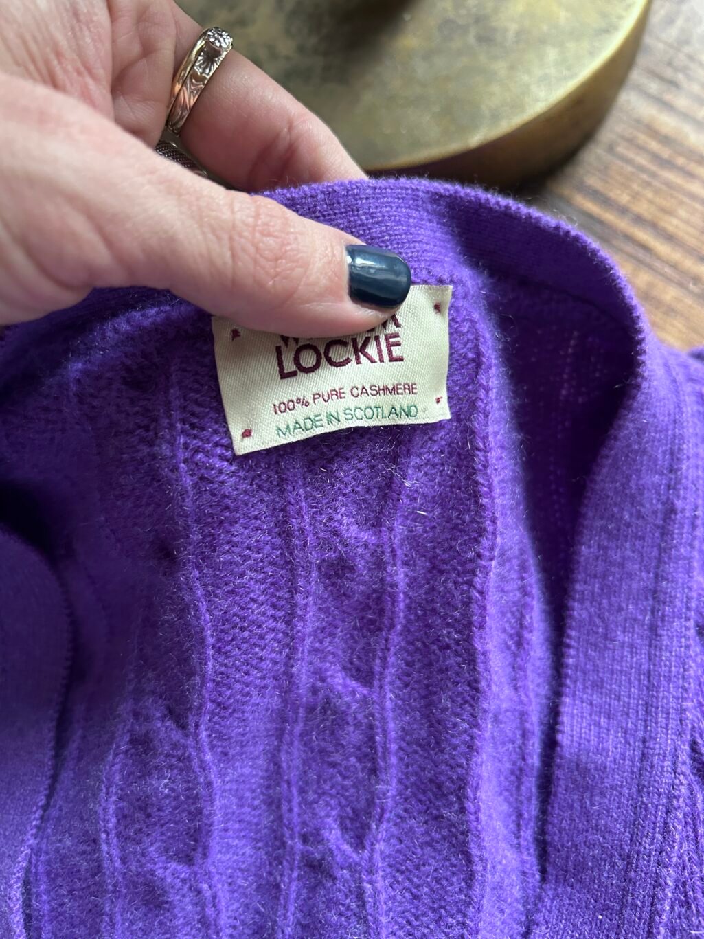 Lila Strick-Cardigan aus 100% Kaschmir mit Zopfmuster.