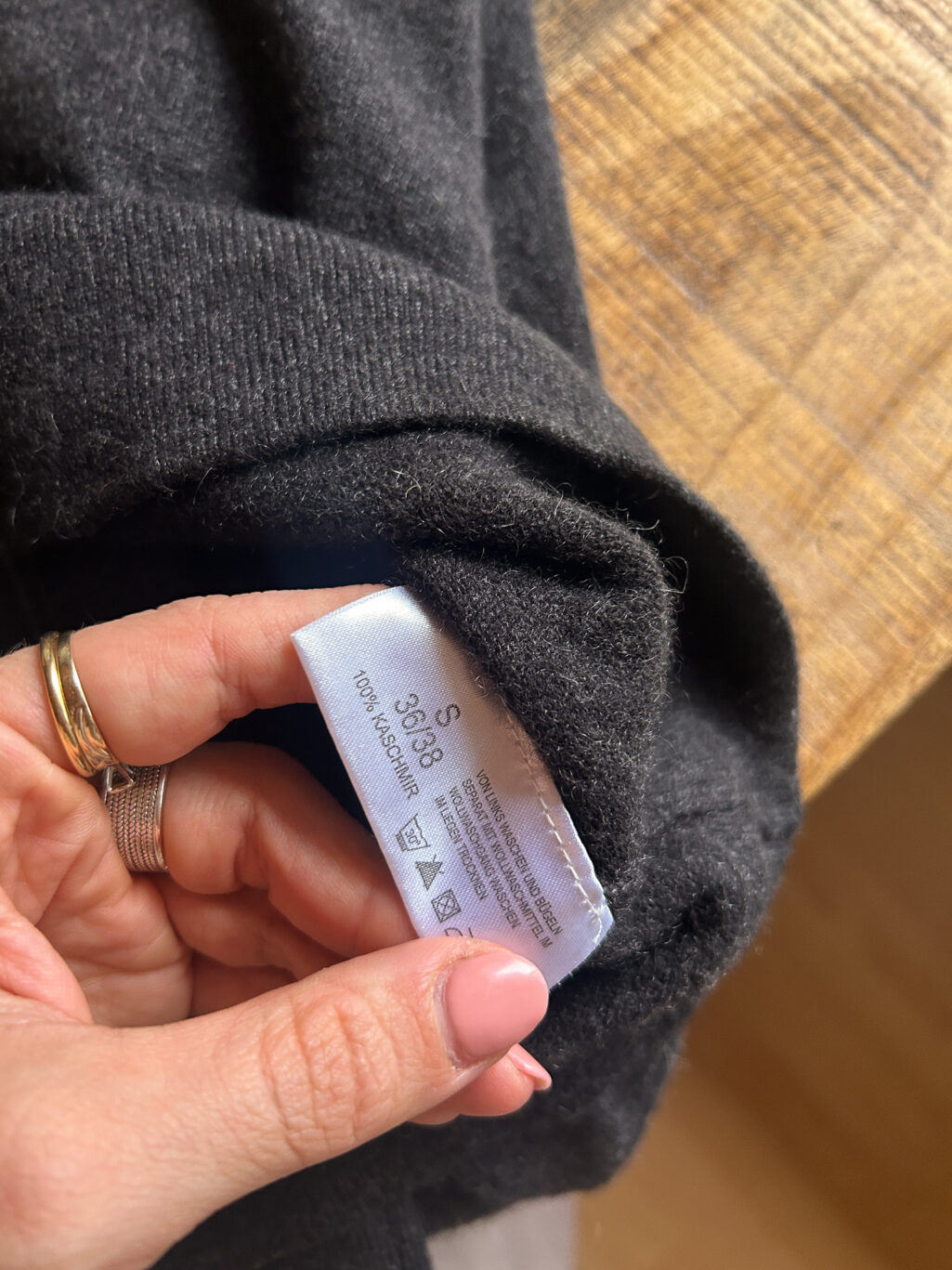 Avenue Foch Cashmere Pullover in Dunkelgrau mit V-Neck. Preloved gefaltet auf Holztisch.