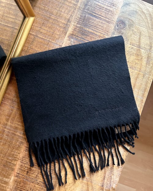 Burberry Cashmere Schal Schwarz Preloved-1 Schwarzer Secondhand Kaschmir Schal von Burberry gefaltet auf Holztisch.