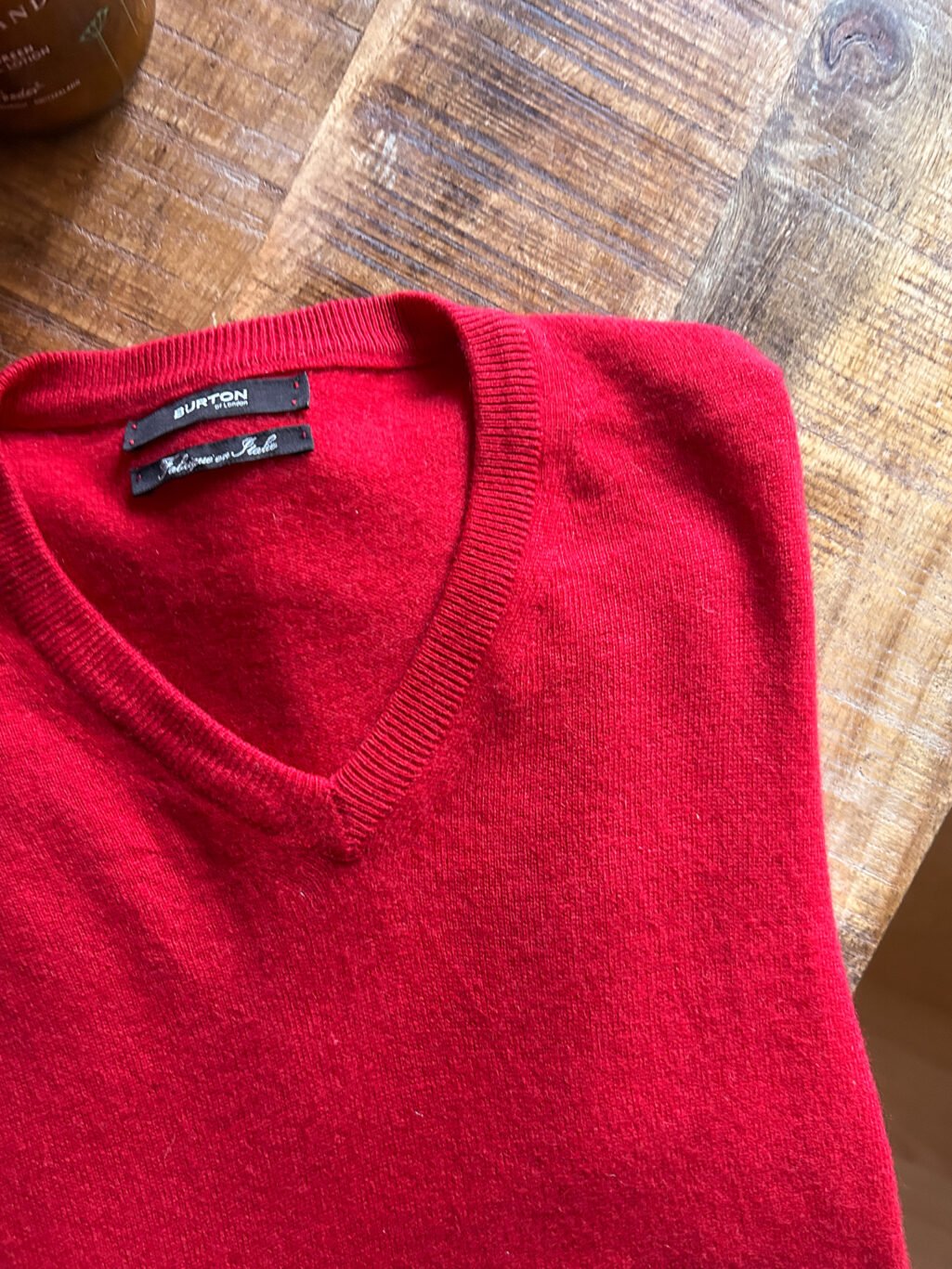 Burton of London Cashmere Pullover in Rot, gefaltet auf Holztisch. Preloved und kuratiert.