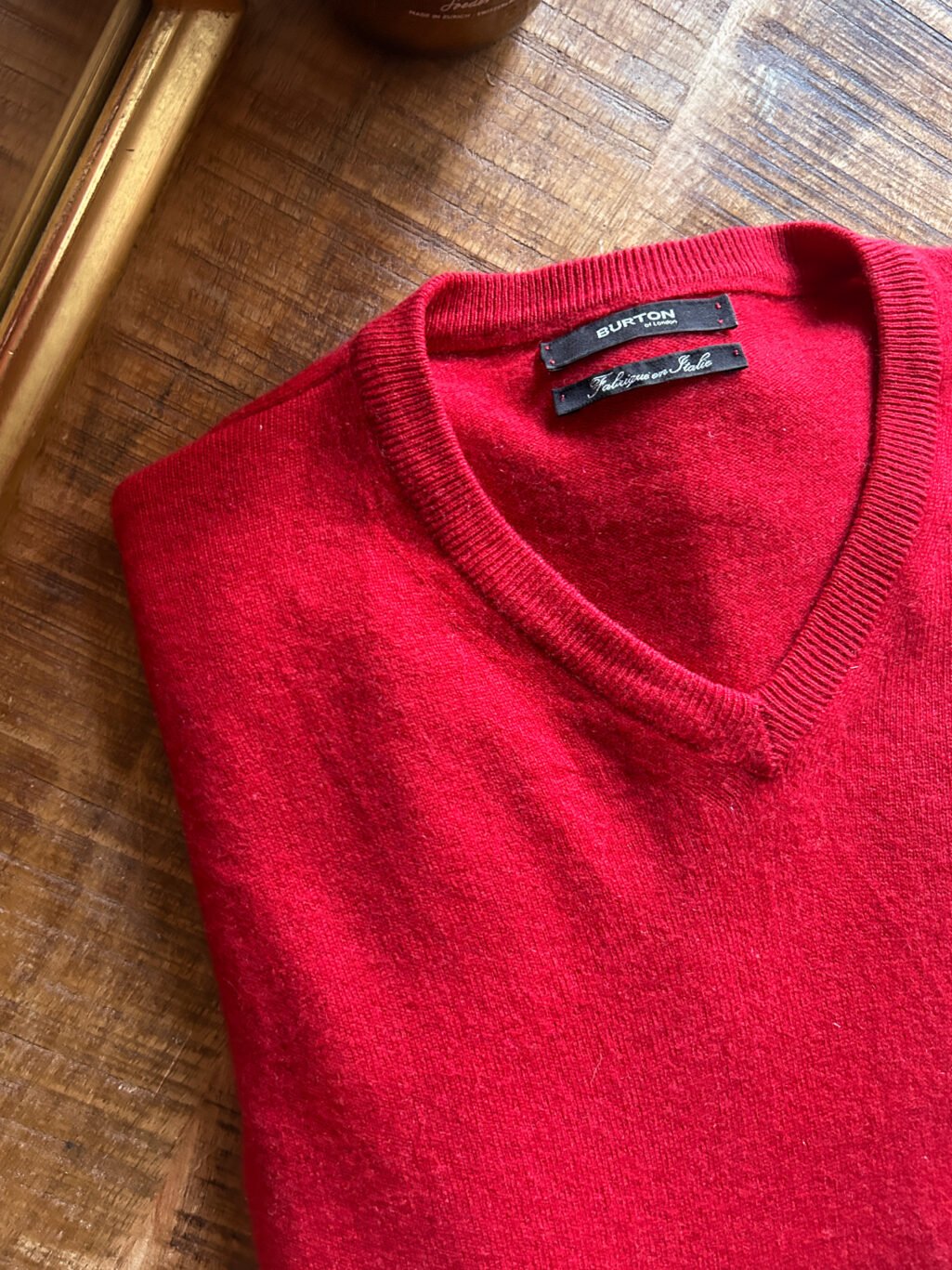 Burton of London Cashmere Pullover in Rot, gefaltet auf Holztisch. Preloved und kuratiert.
