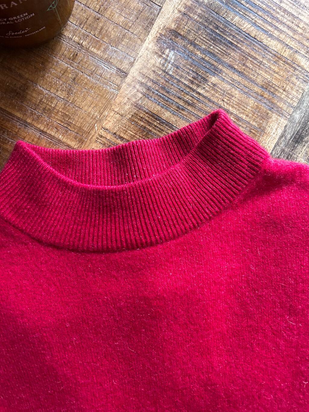 Monkky Cashmere Pullover mit hohem Kragen in Himbeerrot. Preloved. Gefaltet auf Holztisch.