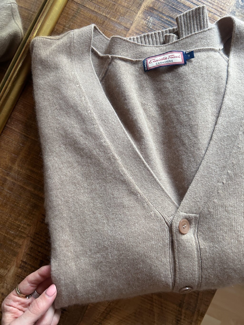 Cashmere in sch&ouml;nem Beige. Secondhand, gefaltet auf Holztisch.