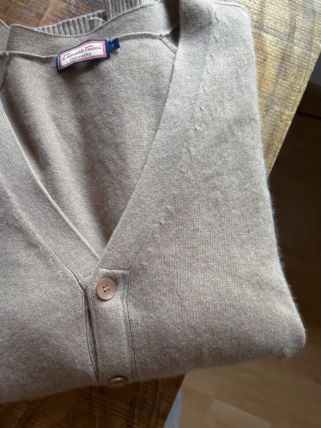Cashmere in sch&ouml;nem Beige. Secondhand, gefaltet auf Holztisch.