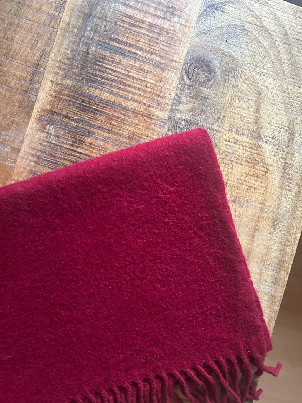 Weinroter Cashmere Schal, preloved von Emmanuelle Khanh. Gefaltet auf Holztisch.