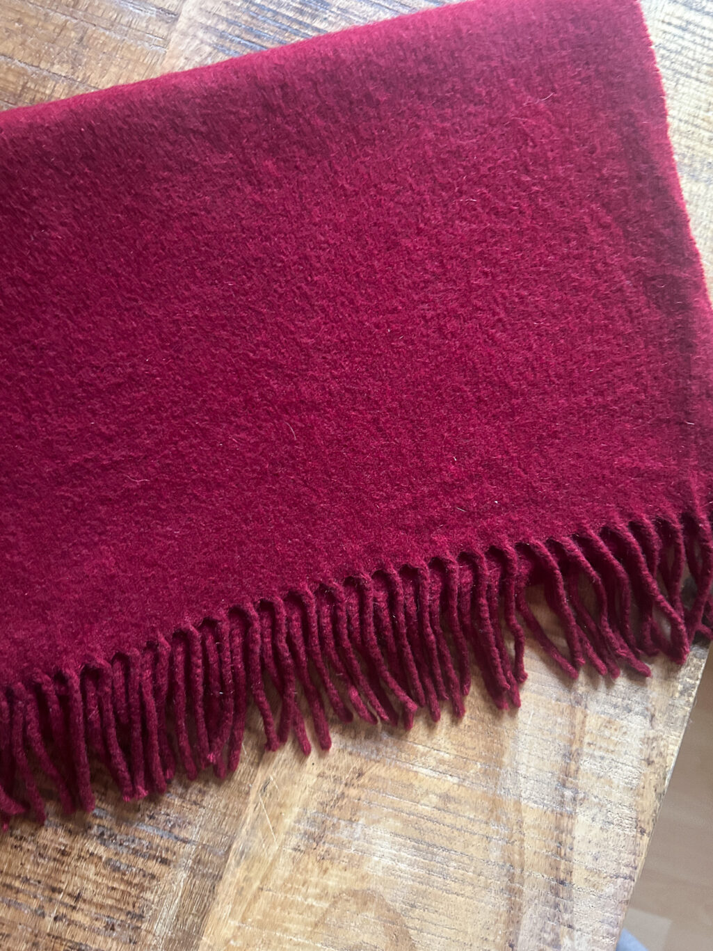 Weinroter Cashmere Schal, preloved von Emmanuelle Khanh. Gefaltet auf Holztisch.