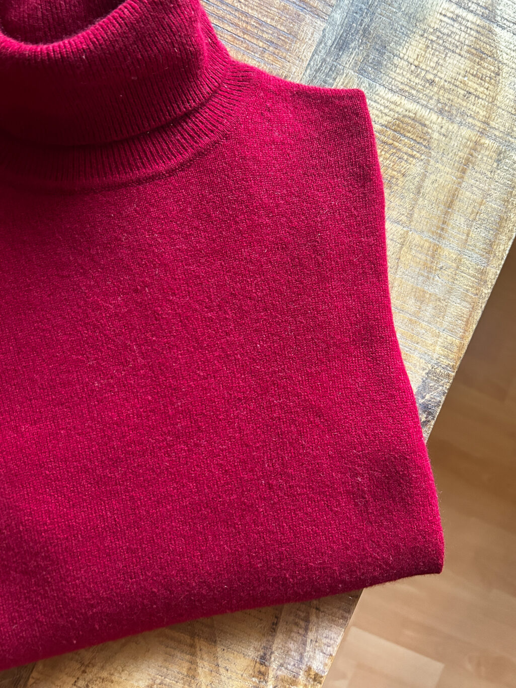 Eric Bompard 100% Cashmere Rollkragen Pullover in Himbeerrot. Preloved. Gefaltet auf Holztisch.