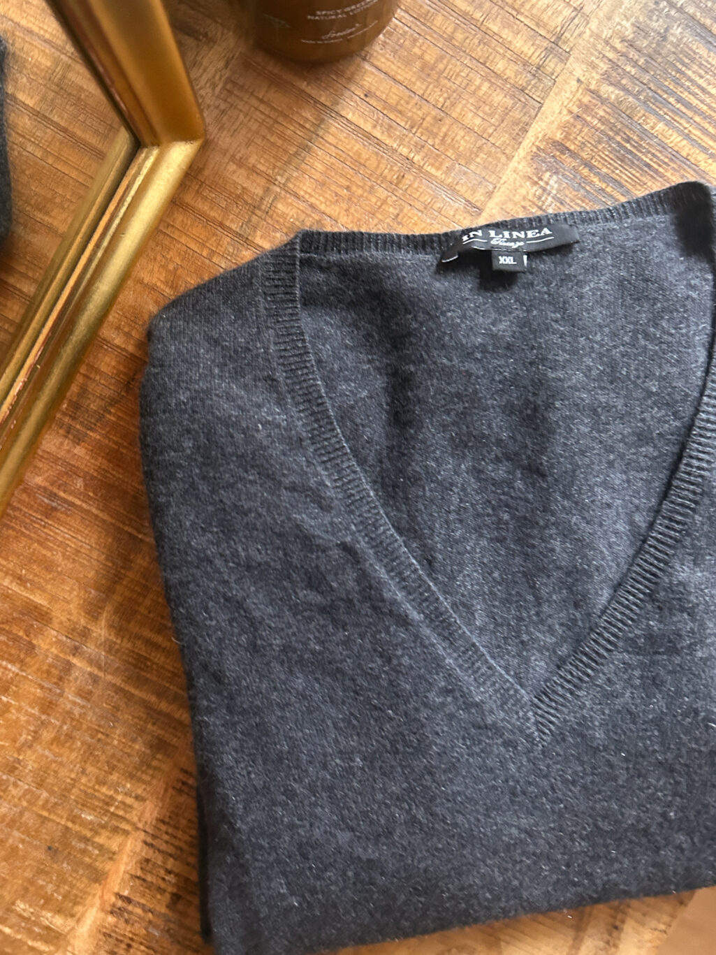 In Linea Firenze grauer preloved Cashmere Pullover mit V-Neck, gefaltet auf Holztisch.