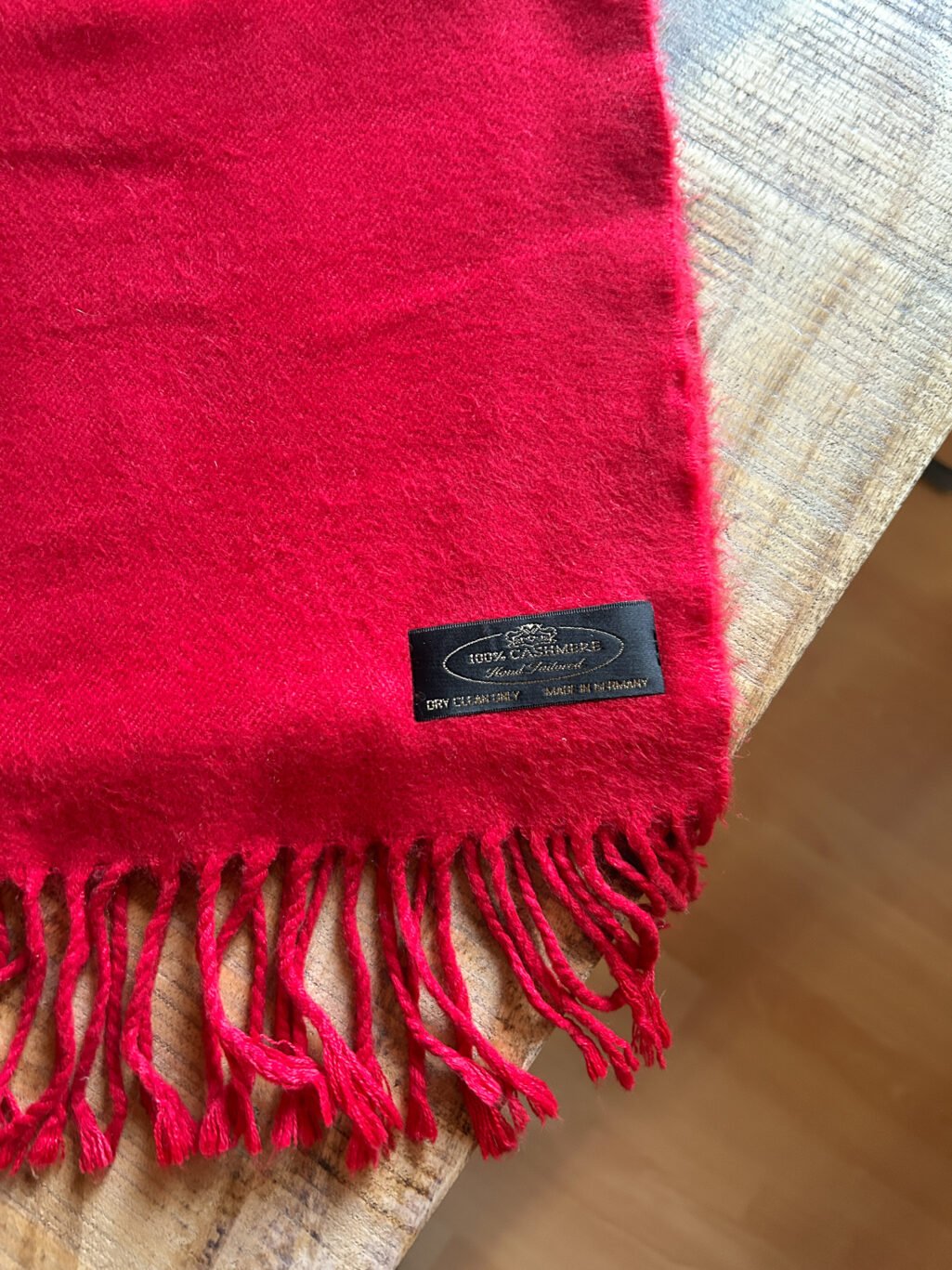 Monkky preloved Kaschmir Schal in Rot. Handgefertigt in Deutschland, gefaltet auf Holztisch.