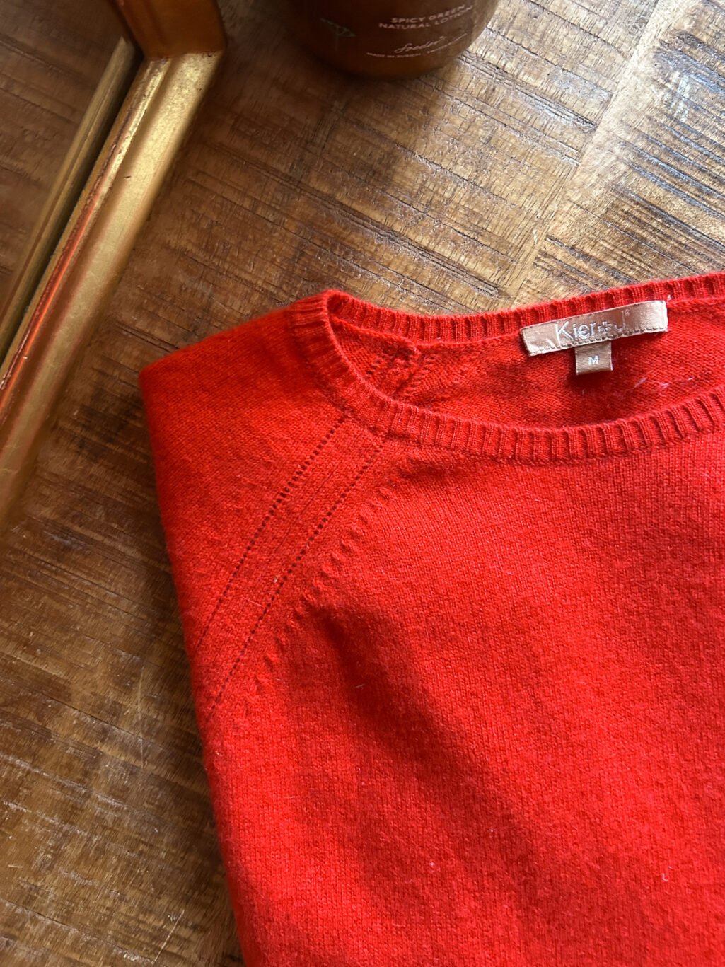 Kier&J Cashmere Pullover, preloved in Rot Orange. Gefaltete auf Holztisch.