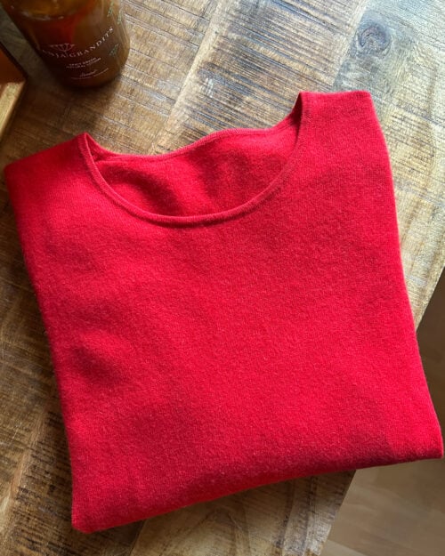 Roter Kaschmir Pullover mit Rundhals-Ausschnitt von Monkky. Preloved und modern. Gefaltet auf Holztisch.