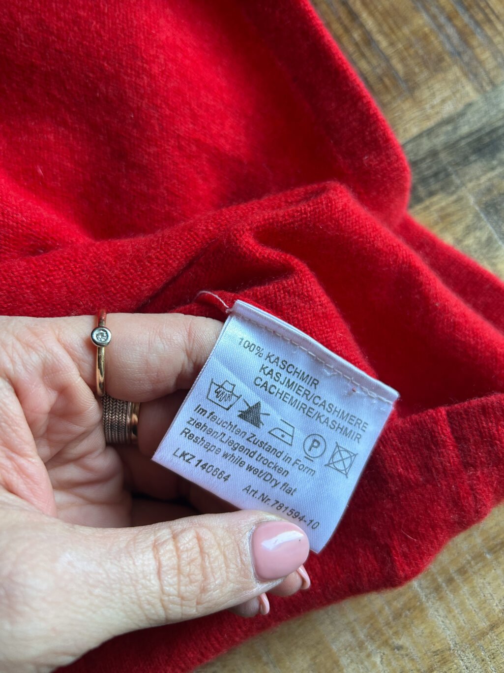 Roter Kaschmir Pullover mit Rundhals-Ausschnitt von Monkky. Preloved und modern. Gefaltet auf Holztisch.