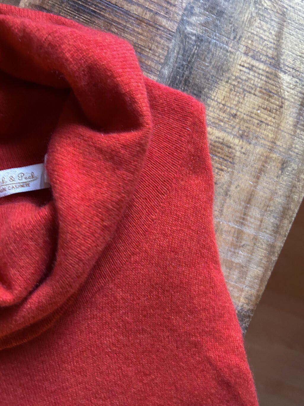 Peck&Peck Rollkragen Pullover, preloved aus 100% Kaschmir, gefaltet auf Holztisch.