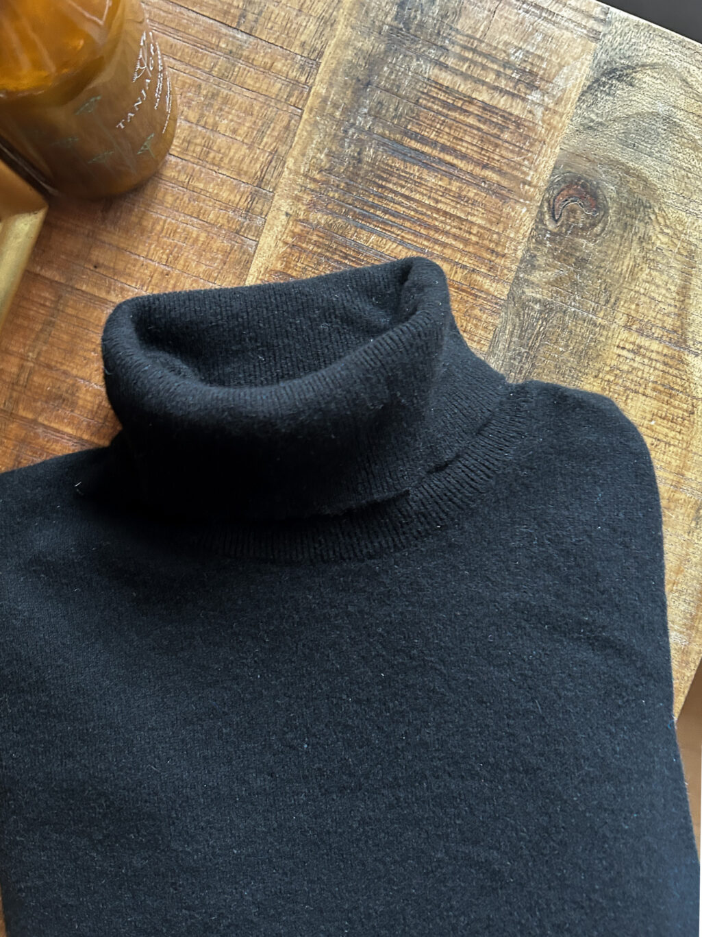 Plus Ultra Cashmere Rollkragen in Schwarz f&uuml;r Herren. Secondhand. Gefaltet auf Holztisch.