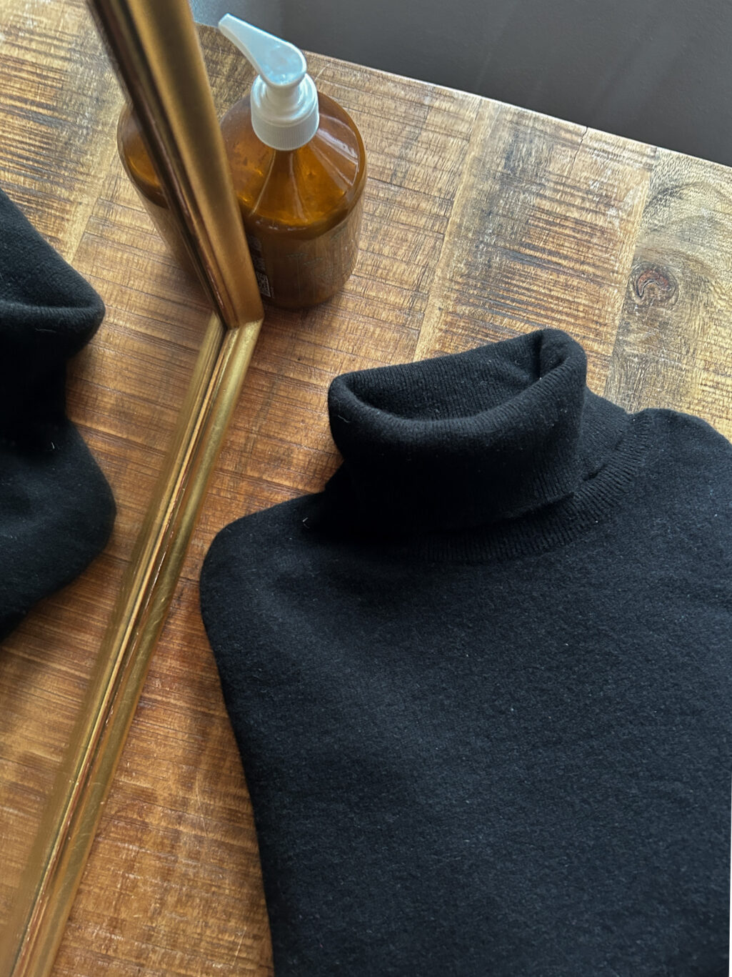 Plus Ultra Cashmere Rollkragen in Schwarz f&uuml;r Herren. Secondhand. Gefaltet auf Holztisch.