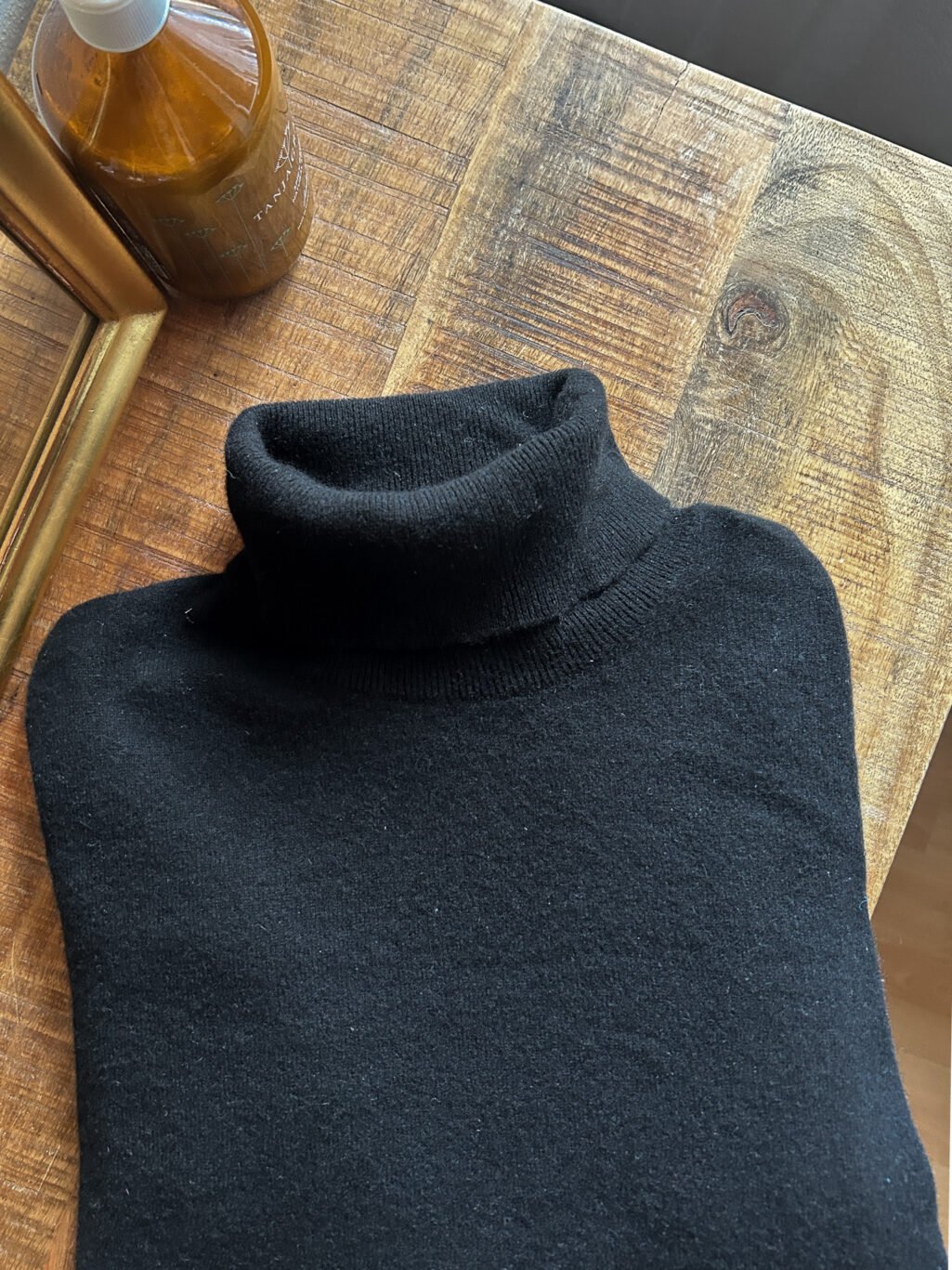 Plus Ultra Cashmere Rollkragen in Schwarz f&uuml;r Herren. Secondhand. Gefaltet auf Holztisch.