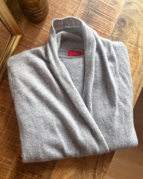 Tissaia, preloved 100% Cashmere Cardigan in Grau, gefaltet auf Holztisch.