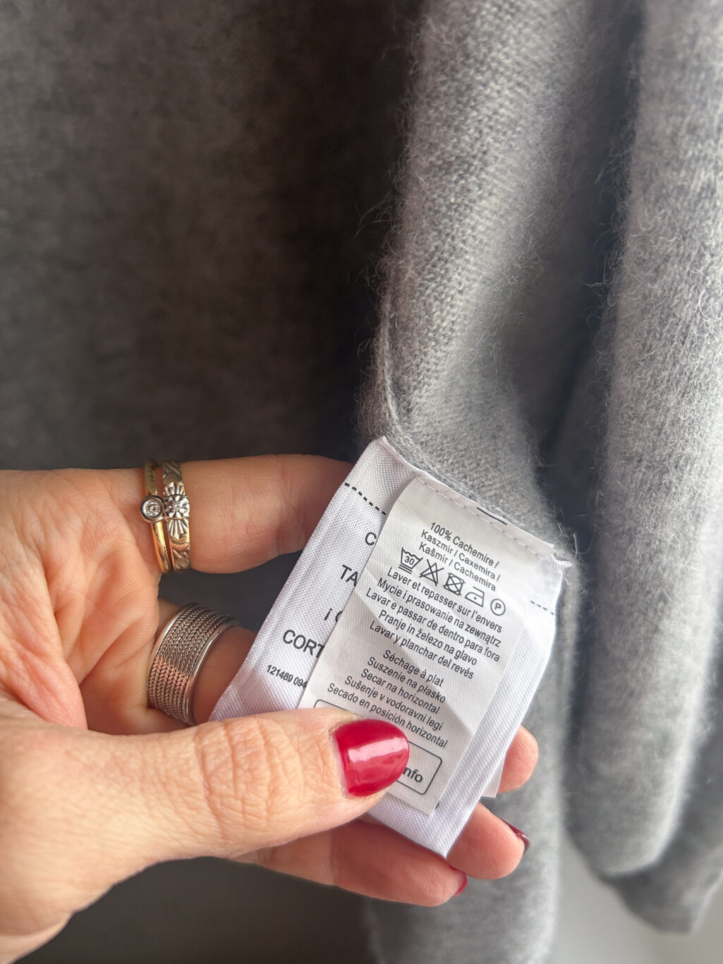 Tissaia, preloved 100% Cashmere Cardigan in Grau, gefaltet auf Holztisch.