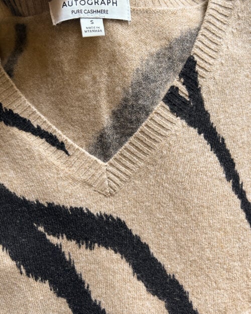 Cashmere Pullover von Autograph mit V-Neck in Beige / Braun mit Animal Print. Secondhand gefaltet auf Holztisch.