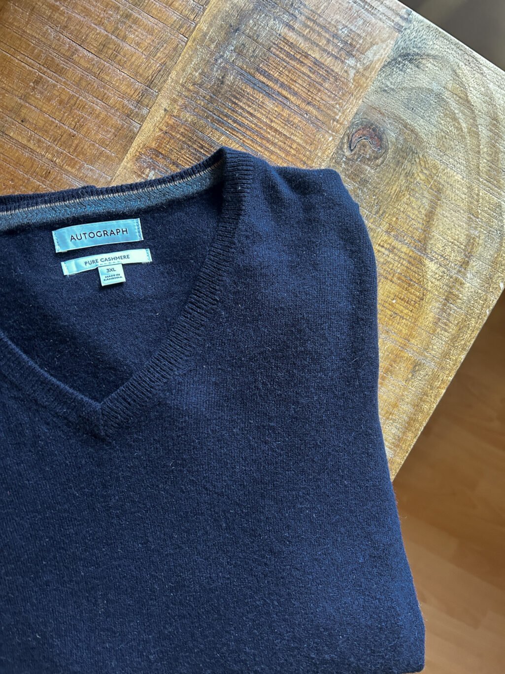 Dunkelblauer Autograph Cashmere Pullover f&uuml;r Herren mit V-Neck. Preloved, gefaltet auf Holztisch.