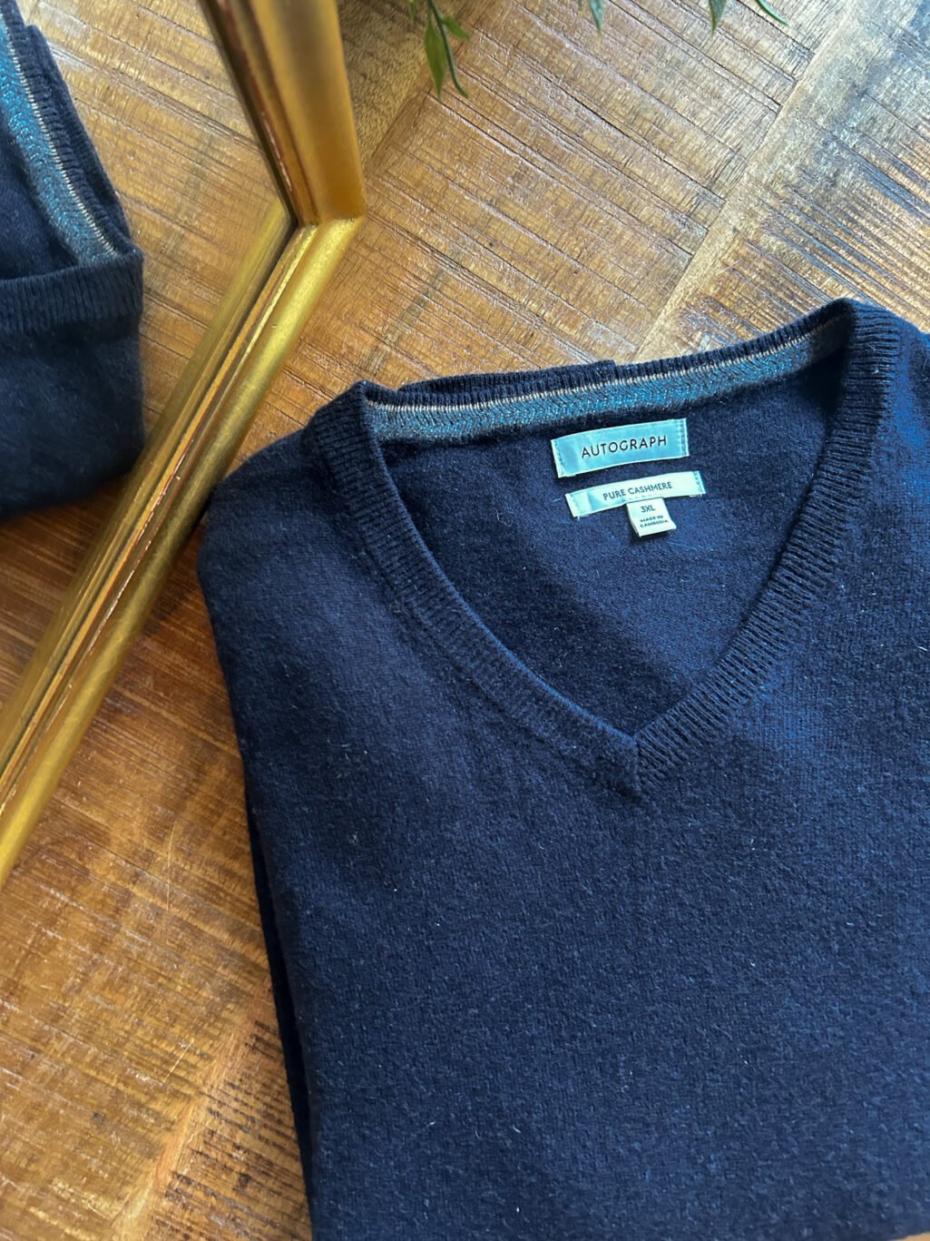 Dunkelblauer Autograph Cashmere Pullover f&uuml;r Herren mit V-Neck. Preloved, gefaltet auf Holztisch.