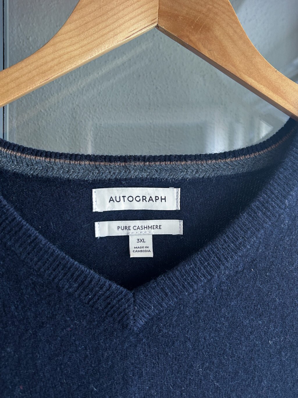 Dunkelblauer Autograph Cashmere Pullover f&uuml;r Herren mit V-Neck. Preloved, h&auml;ngend an Kleiderb&uuml;gel.