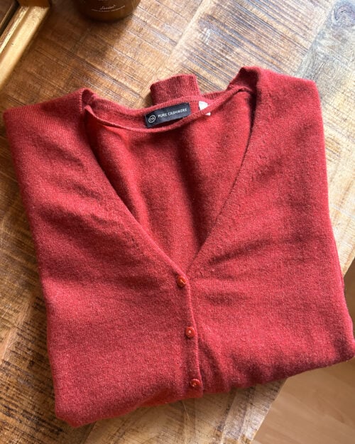 C&A Cashmere Cardigan in Orange Rot mit Kn&ouml;pfen. Preloved. Gefaltet auf Holztisch.